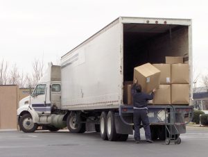 Man off loads boxes from an 18 wheeler